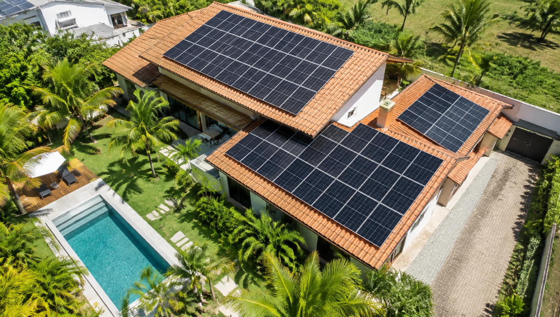 Vista aérea de residência com painéis solares instalados no telhado